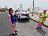 Pilipino doctor Maria Lagbes (L) and a driver stand next to a pink ambulance of the Women Responders team in Dubai. / AFP PHOTO / GIUSEPPE CACACE