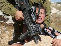 An Israeli soldier arresting a n 11-year-old Palestinian boy.